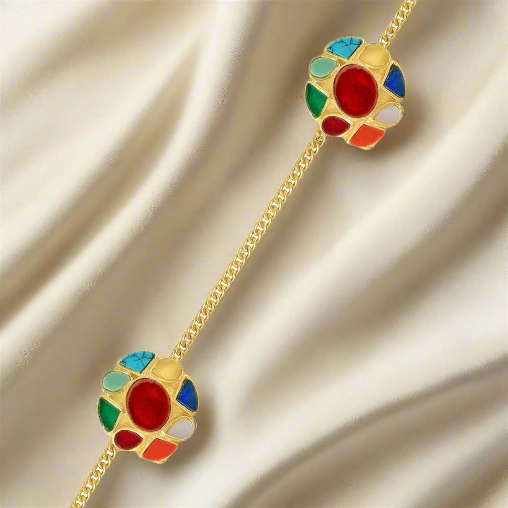 Two gold-colored kurta buttons with multicolored gemstone embellishments on a chain.